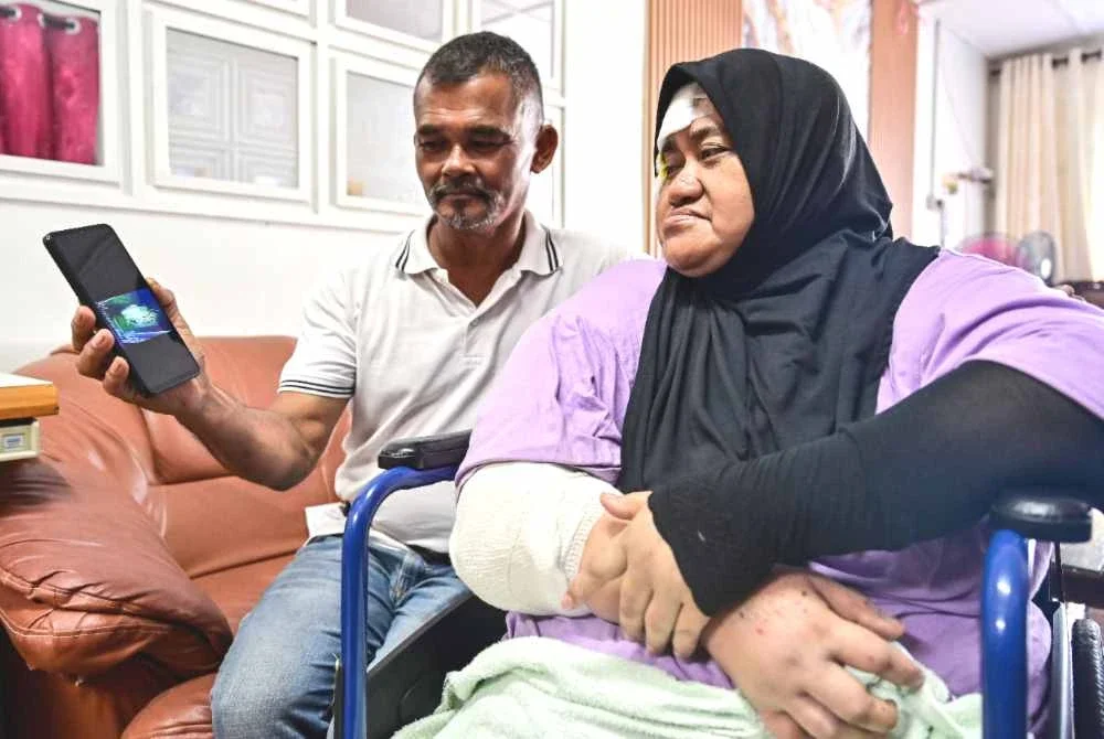 Abdul Wahid bersama isteri, Fauziah (kanan) melihat rakaman dari kamera papan pemuka semasa merempuh sekumpulan gajah liar ketika ditemui di rumahnya di Kampung Pasir Gajah. Foto Bernama