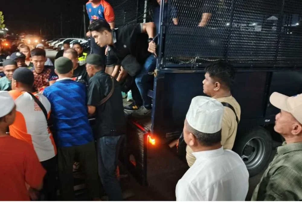 Ruslan (dua dari kanan) dan Isnin (kanan) hadir ke Hospital Beaufort bagi memberikan penghormatan terakhir kepada tiga anggota polis terbabit.