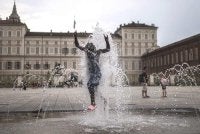 Seorang kanak-kanak menyejukkan badan di sebuah pancuran air awam di Piazza Castello, Turin, ketika gelombang haba melanda bandar itu. Foto AFP