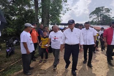 Wan Rosdy diiringi Shafik Fauzan pada program Jelajah Aspirasi Pahang 1st Dewan Undangan Negeri (DUN) Inderapura di Jeti Nelayan Sungai Belat, Kampung Belukar pada petang Rabu. Foto Sinar Harian 