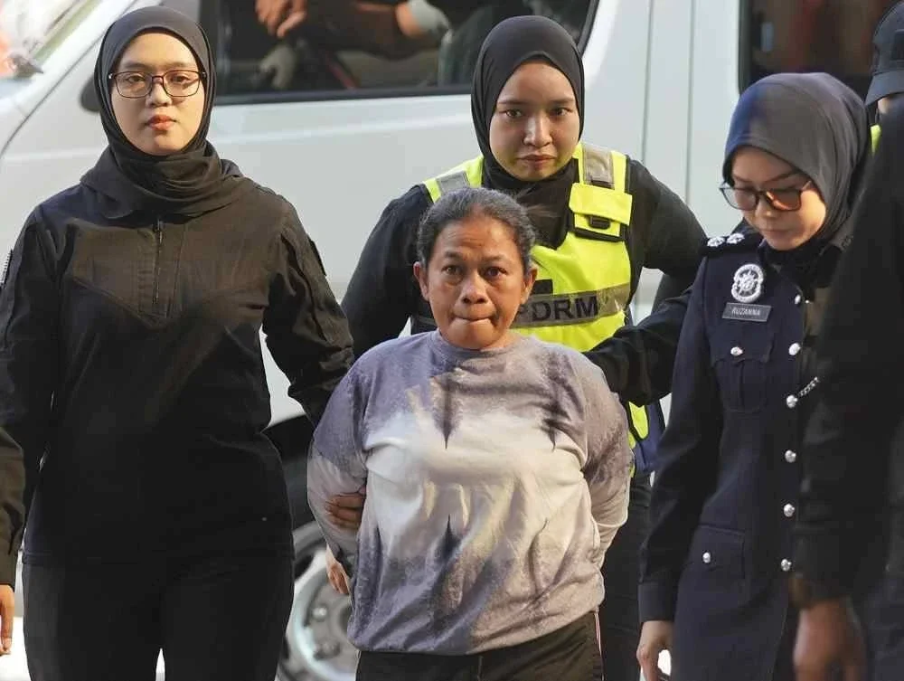 Wahyuni (tengah) ketika dibawa ke Mahkamah Sesyen Kuala Lumpur pada Jumaat bagi menghadapi pertuduhan pengabaian meninggalkan seorang kanak-kanak lelaki berusia dua tahun tiga bulan di kolam renang dewasa tanpa pengawasan sehingga menyebabkan mangsa lemas. Foto: Rosli Talib.