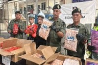 Mohd Shuhaily menunjukkan daging ayam sejuk beku yang disita APKS di salah sebuah kontena semasa sidang akhbar di Pelabuhan Sepanggar, Kota Kinabalu.