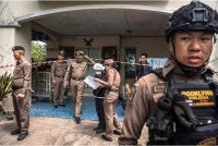 Polis berada di rumah datuk suspek yang turut menjadi mangsa tembakan. Foto: AFP