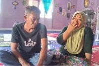 Ismarubee (kiri) bersama isteri, Nor Azila ketika ditemui di rumahnya di Felda Kerteh 2, Dungun pada Jumaat.