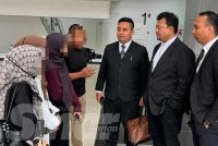 Kamal Hisham (dua dari kanan) berbincang dengan anak guamnya di Mahkamah Sesyen Ampang pada Jumaat.