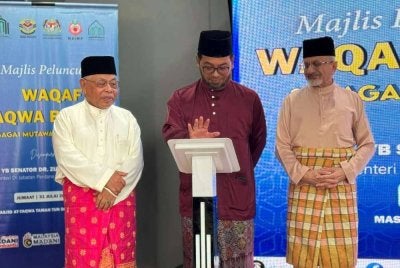 ZULKIFLI (tengah) diiringi Syed Kamarulzaman (kanan) dan Mohd Fadzli (kiri) ketika gimik peluncuran Waqaf Taqwa Berhad.