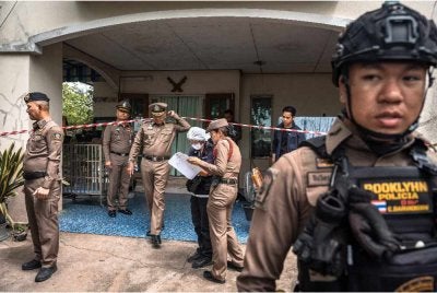 Polis berada di rumah datuk suspek yang turut menjadi mangsa tembakan. Foto: AFP