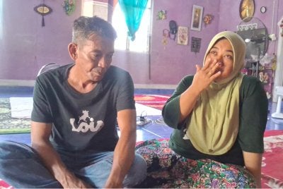 Ismarubee (kiri) bersama isteri, Nor Azila ketika ditemui di rumahnya di Felda Kerteh 2, Dungun pada Jumaat.