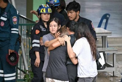 Orang ramai menenangkan isteri seorang guru yang terbunuh dalam insiden tembakan di sebuah sekolah di daerah Bang Kruai, wilayah Nonthaburi, utara ibu negara Thailand, Bangkok, pada Jumaat. Foto: AFP