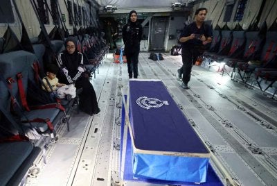 Balu Allahyarham Koperal Mohamad Nur Hafiz, Fatimah Shahira (kanan) bersama anaknya mengiringi jenazah suaminya menerusi penerbangan ihsan TUDM dari Terminal Dua Lapangan Terbang Antarabangsa Kota Kinabalu ke Kuantan, Pahang pada Jumaat. 