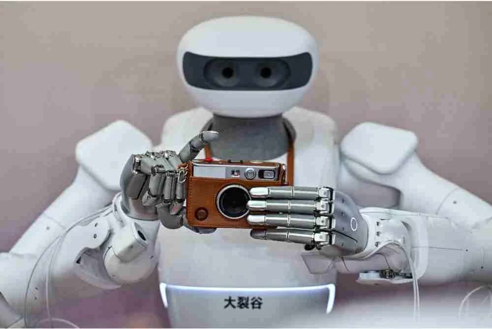 Sebuah robot menunjukkan keupayaannya untuk menggunakan kamera Instax. Foto: AFP