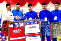 Asyraf Wajdi (tengah) menerima cenderamata yang disampaikan semasa merasmikan Majlis Perasmian Mesyuarat Perwakilan UMNO Bahagian Kota Bharu, Empat Peringkat Tahun 2026 di Dewan UMNO Negeri Kelantan di Kota Bharu pada Sabtu. 