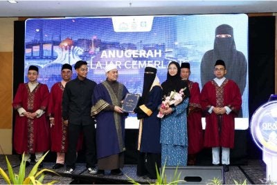 Mohd Sukki (empat dari kiri) menyampaikan sijil kepada salah seorang graduan pada Majlis Graduasi Iltizam Huffaz.
