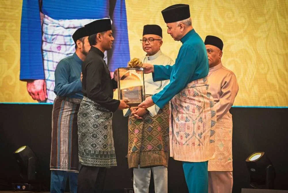 Khairruddin (kiri) menerima Anugerah Ikon Asnaf yang disampaikan Sultan Perak, Sultan Nazrin Shah.