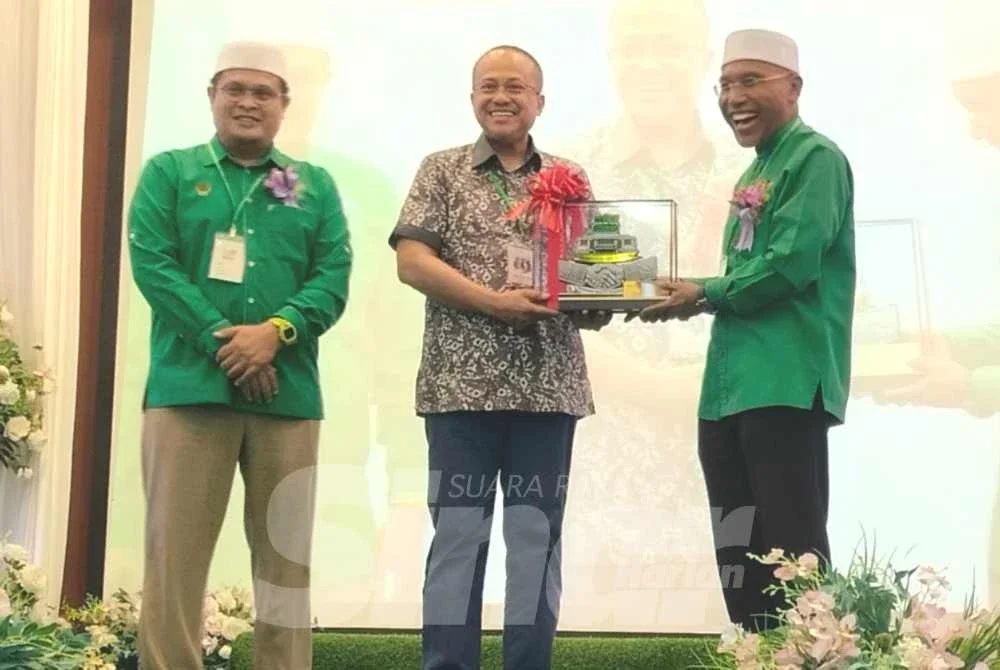 Ahmad Samsuri (tengah) menerima cenderahati daripada Idris (kanan) selepas merasmikan Konvensyen Pas Perak kali ke-23 di Hotel Perdana pada Ahad.