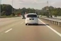 Tular aksi seorang penumpang mengeluarkan sebahagian badannya melalui tingkap belakang Perodua Alza di Lebuhraya Kajang-Seremban.
