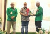 Ahmad Samsuri (tengah) menerima cenderahati daripada Idris (kanan) selepas merasmikan Konvensyen Pas Perak kali ke-23 di Hotel Perdana pada Ahad.
