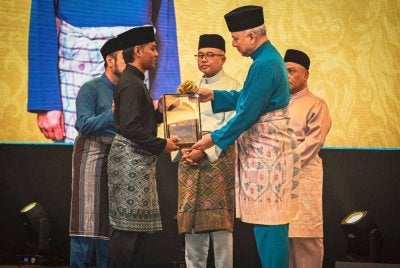Khairruddin (kiri) menerima Anugerah Ikon Asnaf yang disampaikan Sultan Perak, Sultan Nazrin Shah.
