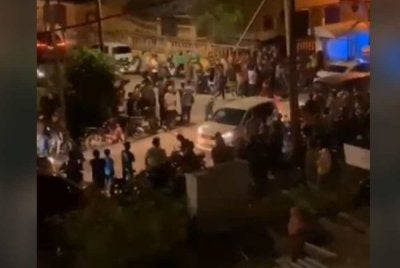 Tangkap layar video tular menunjukkan orang ramai berkumpul di hadapan sebuah hadapan flat di Kampung Enjin Gergaji, Chukai, pada Sabtu.
