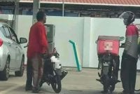 Tangkap layar video tular pada Ahad menunjukkan suspek mengacukan pisau pemotong daging kepada seorang penghantar makanan yang sedang mengisi minyak di sebuah stesen minyak di Jalan Pasir Panjang, Kuala Terengganu.
