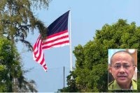 Gambar tular menunjukkan bahagian Jalur Gemilang yang tidak memaparkan lambang bulan dan bintang dipasang di Dataran Batu Buruk, Kuala Terengganu. Gambar kecil: Ahmad Samsuri