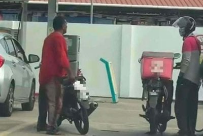 Tangkap layar video tular pada Ahad menunjukkan suspek mengacukan pisau pemotong daging kepada seorang penghantar makanan yang sedang mengisi minyak di sebuah stesen minyak di Jalan Pasir Panjang, Kuala Terengganu.