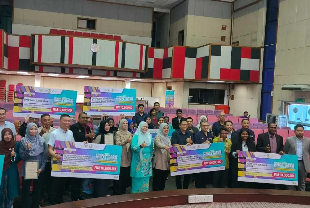 Salbiah (lapan dari kanan) bersama penerima selepas menyempurnakan Majlis Penyerahan Mock Cheque Program Pembolehdayaan Modal Insan dan Pembelajaran Sepanjang Hayat Perak Sejahtera 2030 di Dewan Serbaguna, Bangunan Perak Darul Ridzuan pada Selasa.