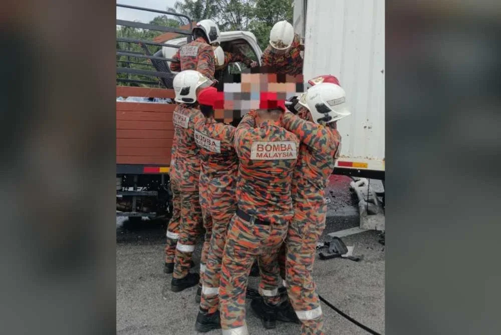 Anggota bomba mengeluarkan mayat mangsa dalam kemalangan di Kilometer 73.3, Lebuhraya Utara Selatan (Arah Utara), Kluang pada Selasa.
