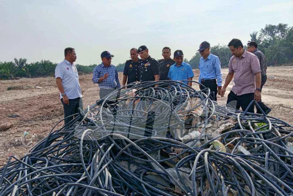 Md Israk (kiri) meninjau tapak penambakan dan pembuangan sisa binaan di Kampung Sungai Senai, Kukup pada Selasa.