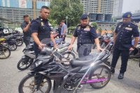 Muhammad Kifli (dua dari kanan) melihat motosikal yang disita menerusi Op Ekstrem di ibu negara.