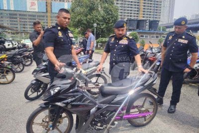 Muhammad Kifli (dua dari kanan) melihat motosikal yang disita menerusi Op Ekstrem di ibu negara.