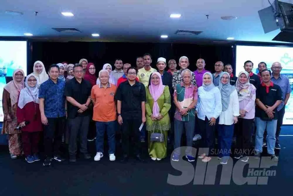 Muhammad Aiman Syafiq selaku wakil penerima sumbangan bergambar bersama kakitangan dan pengurusan Karangkraf, di sini pada Rabu. FOTO SINAR HARIAN/ MOHD HALIM ABDUL WAHID.