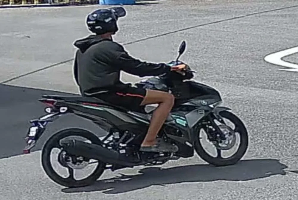 Tangkap layar video rakaman CCTV menunjukkan suspek memakai pakaian serba hitam termasuk seluar pendek serta menaiki motosikal jenis Yamaha Y15ZR berwarna kelabu.