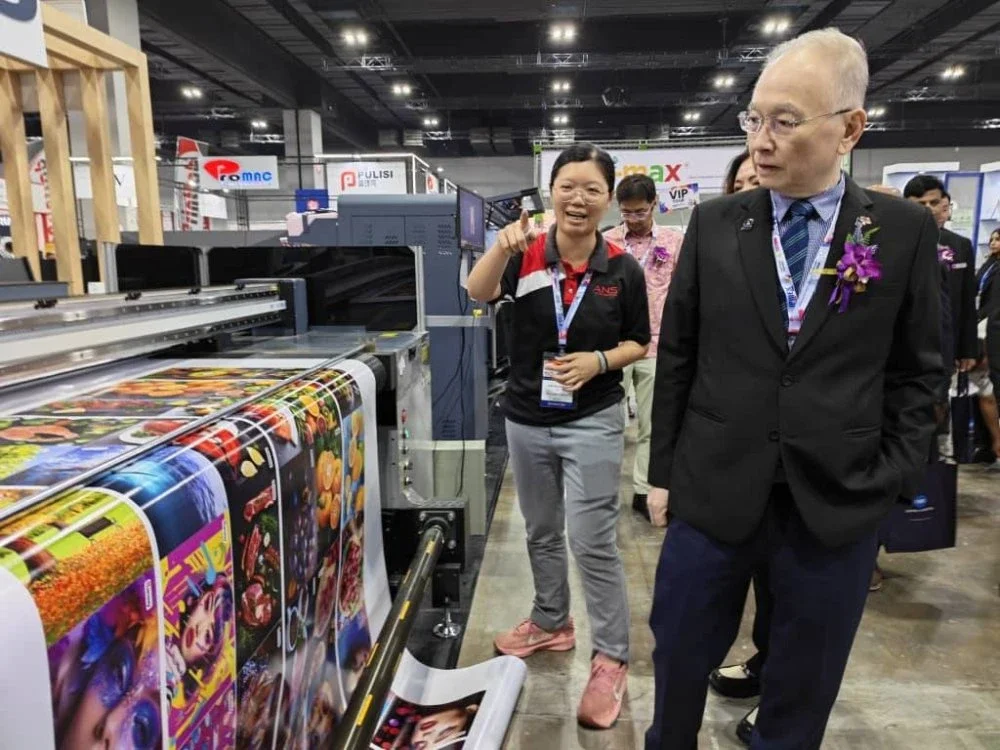 Ka Siong diberi penerangan mengenai mesin percetakan ketika melawat ruang pameran.