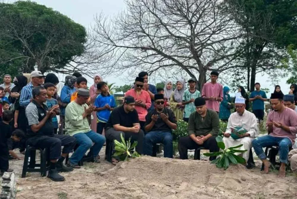 Ahli keluarga dan sahabat Allahyarham Dzulkifli Ali memberi penghormatan terakhir ketika pengebumian di Tanah Perkuburan Islam Bagan Jermal selepas solat Asar pada Rabu - Foto: Bernama/ Erma Idayu