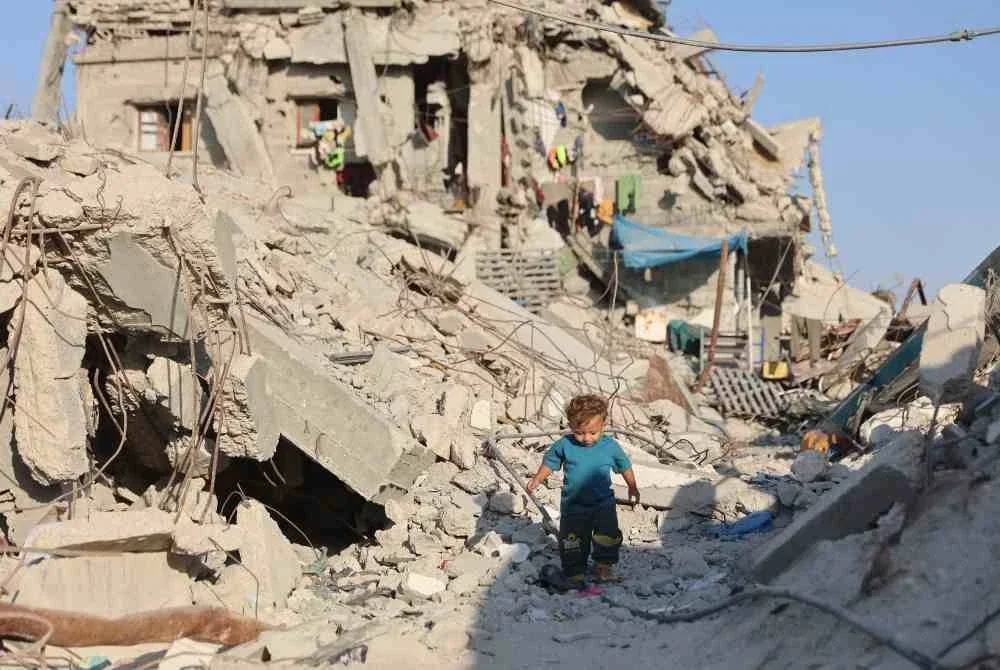Seorang kanak-kanak Palestin berjalan melewati runtuhan bangunan yang musnah di kem pelarian Jabalia, utara Gaza akibat serangan Israel. Foto AFP