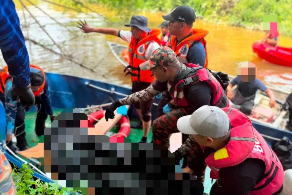 Anggota bomba mengangkat mayat mangsa yang ditemukan lemas di Sungai Kampung Gong Maksom di Kampung Raja, Jertih pada Khamis. - FOTO: Polis