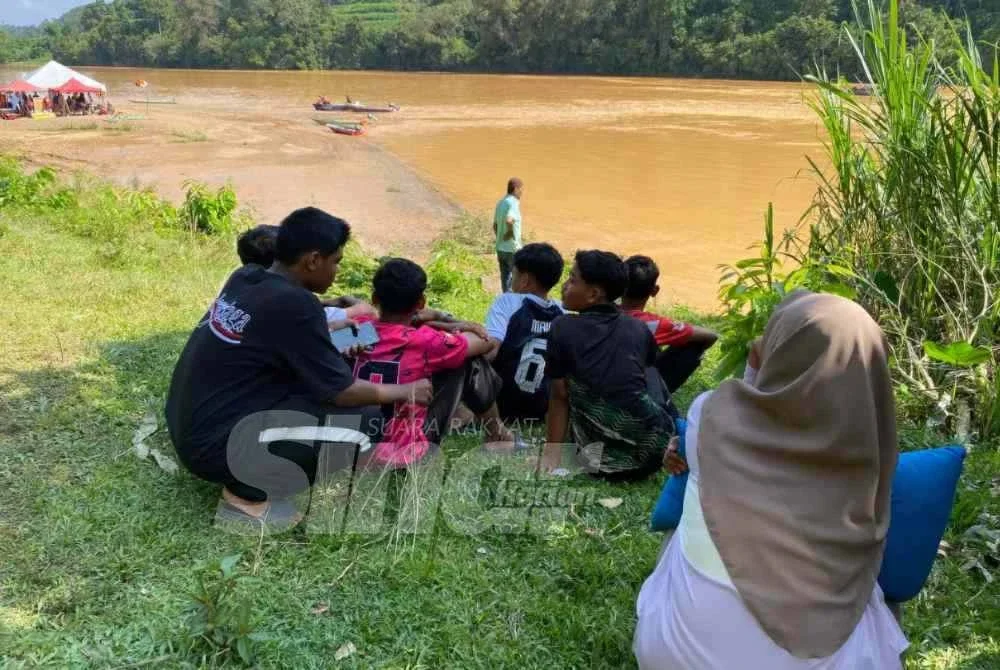 Norhasmiza setia menanti di lokasi kejadian sambil memeluk 'bantal busuk' milik anak lelaki tunggalnya, Muhamad Rayyan yang dikhuatiri lemas di Sungai Kelantan, berhampiran Kampung Batu Mengkebang, Jalan Batu Lada, Aur Duri, Kuala Krai pada Selasa.
