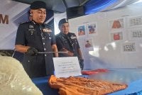 Mohd Alwi (kiri) menunjukkan rampasan dadah bernilai lebih RM18,000 dalam pemeriksaan yang dilakukan polis IPD Manjung di sebuah lokap Balai Polis Lumut, Selasa lalu.