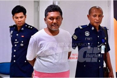 Zawawi (tengah) ketika dihadapkan di Mahkamah Majistret Kuala Terengganu pada Khamis atas dua kesalahan mengejar seorang lelaki sambil membawa pisau pemotong daging dan memasukkan dadah berbahaya ke dalam tubuhnya.