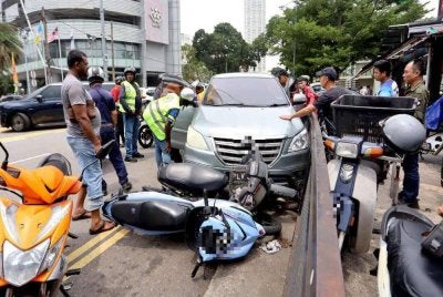 Kereta dipandu mangsa merempuh dua buah motosikal yang diparkir di hadapan sebuah restoran. FOTO: Guang Ming Daily