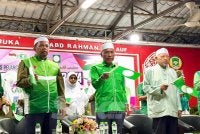 Ahmad (kanan) dan Idris (tengah) mengibarkan bendera Pas ketika nyayian lagu parti itu. FOTO SINAR HARIAN - ADILA SHARINNI WAHID