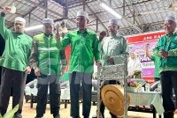 Idris (tengah) memukul gong sebagai simbolik merasmikan Majlis Pelancaran Jentera Pilihan Raya Pas Kawasan Tumpat di Kampung Sedar pada Jumaat.