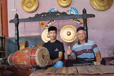 Amar(kanan) bersama Mohd Nizal (kiri) terus mengangkat seni gasing pangkah Johor, gamelan, tarian reog dan wayang kulit Jawa agar khazanah budaya masyarakat Jawa kekal diwarisi generasi akan datang.