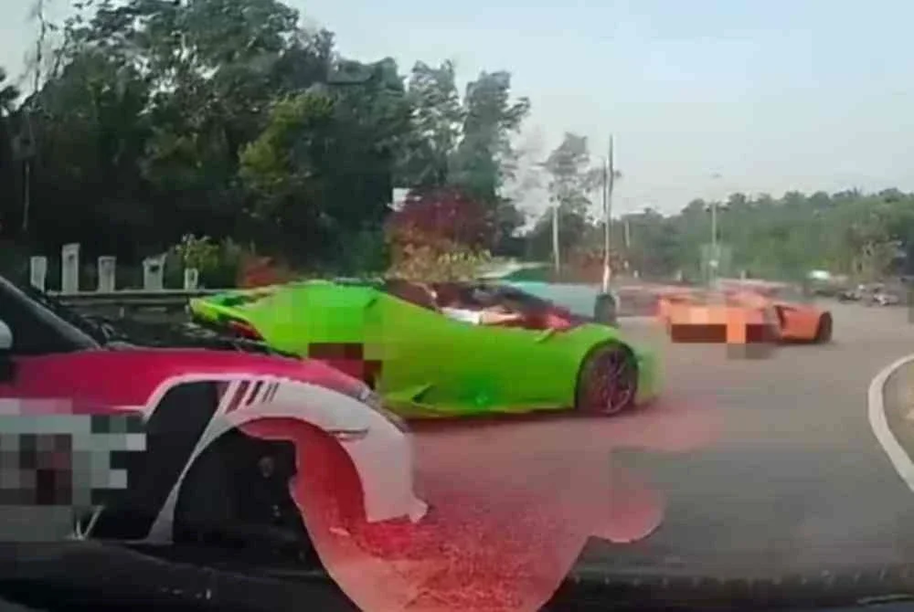 Tangkap layar video tular memaparkan aksi dua ‘marshal’ konvoi supercar menghalang kenderaan awam di bulatan Lebuh Kota Iskandar, Iskandar Puteri.