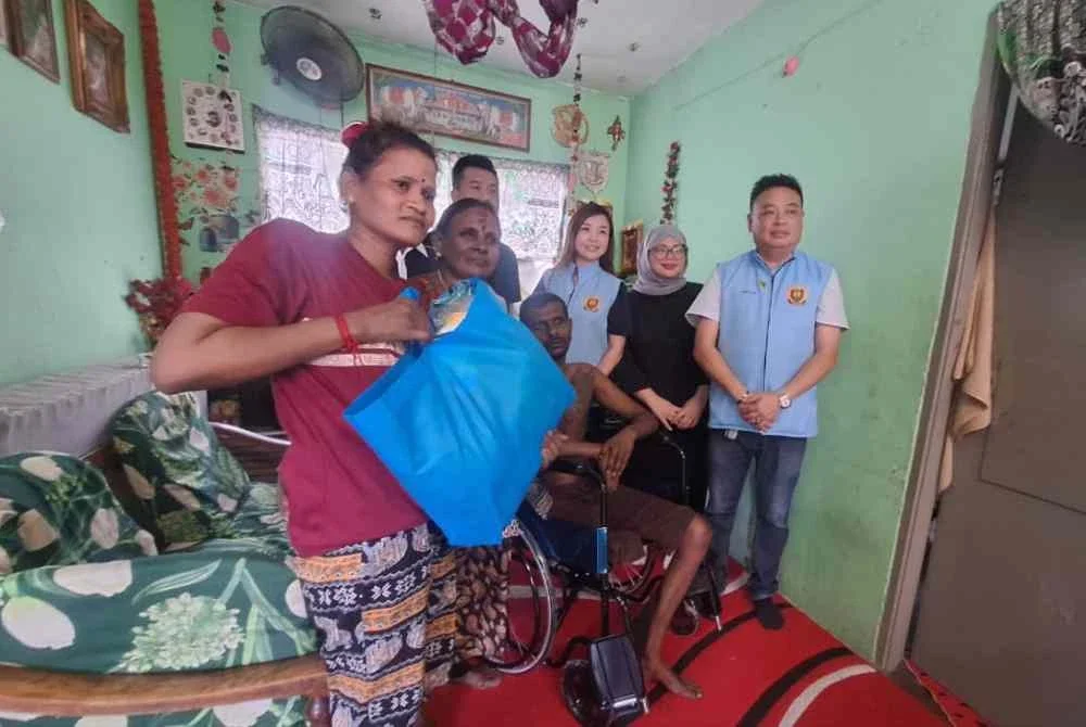 Seng Huat (kanan) menziarahi salah seorang penduduk semasa lawatannya dalam program
Penyampaian Sumbangan Barangan Keperluan dan Cermin Mata Percuma di Pangsapuri Rebana Bandar Bukit Raja di sini pada Ahad.