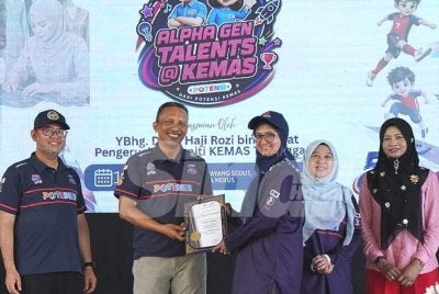 Rozi (dua dari kiri) menyampaikan hadiah sempena Program Alpha Gen Talents@Kemas di Kuala Nerus pada Sabtu.