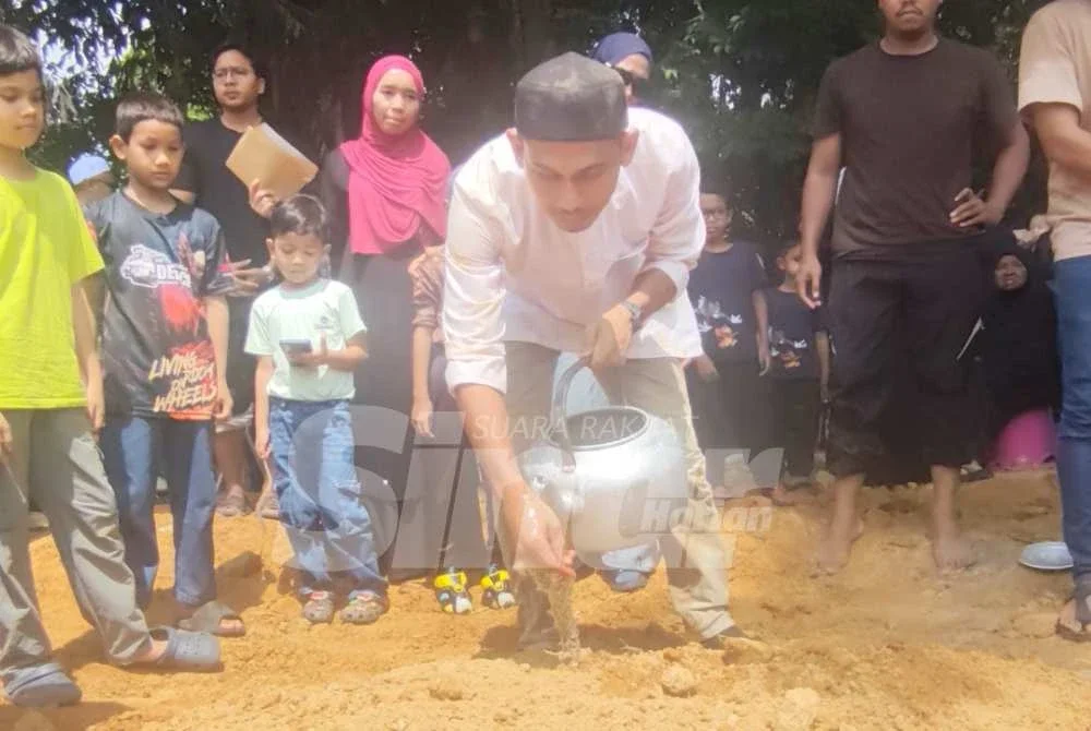 Saifulnizam menyiram air di pusara arwah anaknya, Muhamad Fattah Aisy Naufal di Tanah Perkuburan Islam Kampung Sanggang di Temerloh di sini pada Isnin. Foto SINAR HARIAN/NORAWAZNI YUSOF