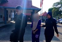 Suspek dibawa keluar dari Mahkamah Majistret Pasir Puteh pada Isnin.