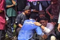 Saifulnizam dipeluk oleh kenalan selepas selesai urusan pengebumian dua beranak di Tanah Perkuburan Islam Kampung Sanggang Temerloh pada Isnin.